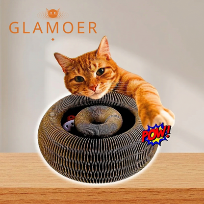 Cat playing with a cardboard tube toy on a wooden surface, with 'GLAMOER' branding.